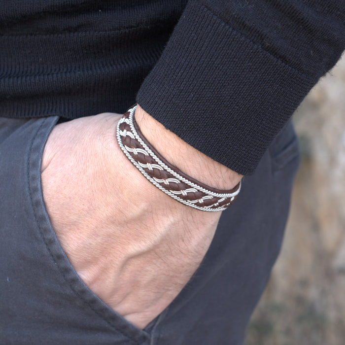 Handgjort armband i renskinn med tenntrådsfläta och renhornsknapp, inspirerat av Kebnekaise och fjällens kraftfulla landskap.