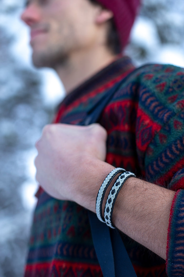 VINTER är ett handgjort armband i renskinn med traditionell tenntrådsfläta, inspirerat av vinter, samiskt arv och den nordiska naturens stillhet.