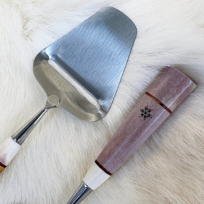 En fin och exklusiv osthyvel med handtag av polerat renhorn med gravyr. Köp hos Arctic Collection