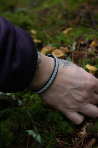 Tennarmband handflätat i tenntråd och silver på mjukt renskinn, inspirerat av naturen i Norrland och Swedish Lapland.