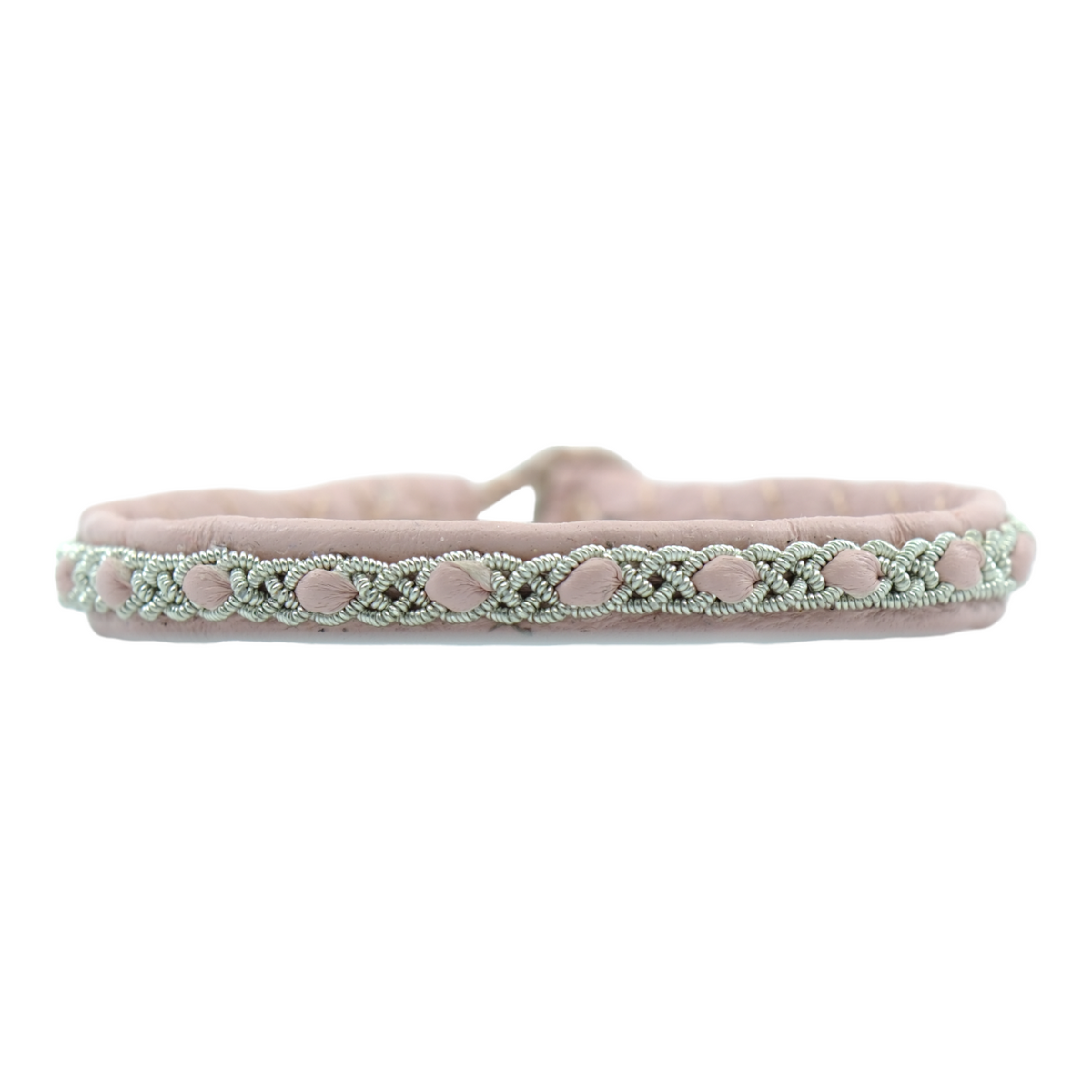 Handgjort smalt armband i renskinn med tenntrådsfläta och renhornsknapp, inspirerat av naturens lugn och nordisk enkelhet.
