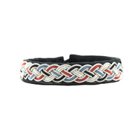 Handgjort armband i svart renskinn med färgstark tenntrådsfläta och renhornsknapp, inspirerat av Gammelstad Kyrkstad och dess historiska miljö.
