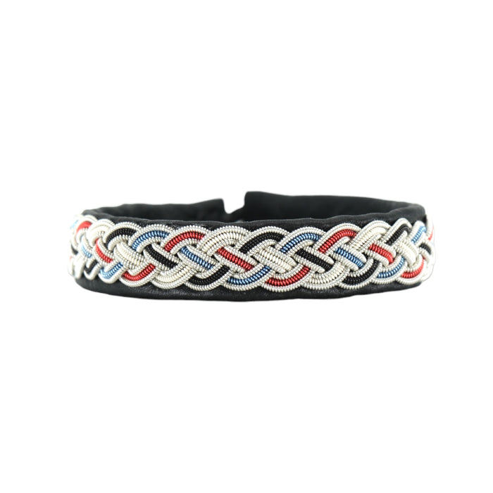 Handgjort armband i svart renskinn med färgstark tenntrådsfläta och renhornsknapp, inspirerat av Gammelstad Kyrkstad och dess historiska miljö.
