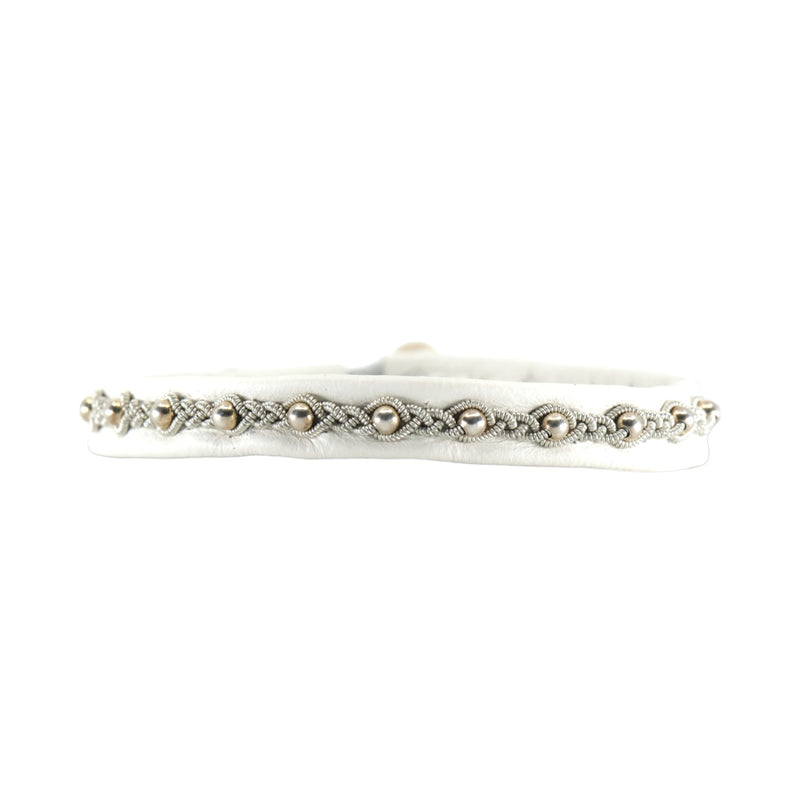 Elegant handgjort armband i renskinn med tenntråd och silverpärlor, som fångar känslan av midnattssolens skimrande ljus.
