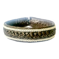 Handgjort armband i renskinn med tenntrådsfläta och renhornsknapp, inspirerat av tundrans öppna landskap och nordisk vildmark.
