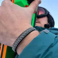 Handgjort tennarmband i renskinn med tenntrådsfläta och renhornsknapp
