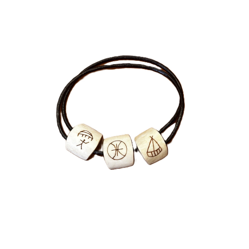 Armband i justerbart läder med tre renhornspärlor graverade med traditionella samiska symboler.