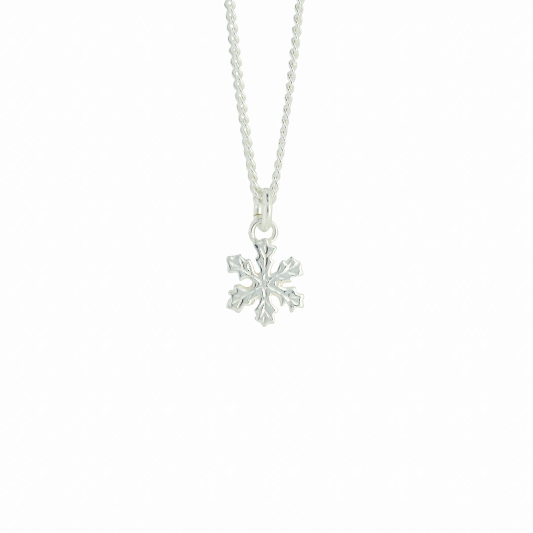 ett silverhalsband med en liten hängandes snöstjärna i silver med vit bakgrund