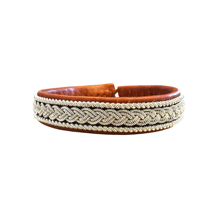 armband i ljusbrunt renskinn med tenntrådsfläta i närbild med vit bakgrund.