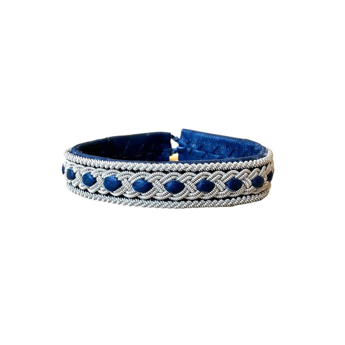 Tennarmband Kyla från Arctic Collection i mörkblått renskinn med handflätad tenntråd. Närbild på armbandet.