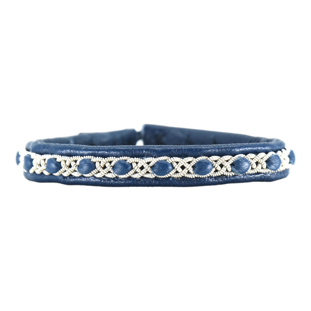 Närbild på tennarmbandet Snö från Arctic Collection, handgjort i blått renskinn med silverfärgad tenntrådsfläta. Armbandet visas framifrån mot vit bakgrund