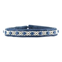 Närbild på tennarmbandet Snö från Arctic Collection, handgjort i blått renskinn med silverfärgad tenntrådsfläta. Armbandet visas framifrån mot vit bakgrund