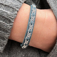 Handgjort smalt armband i skinn med renhornsknapp, visas på handled