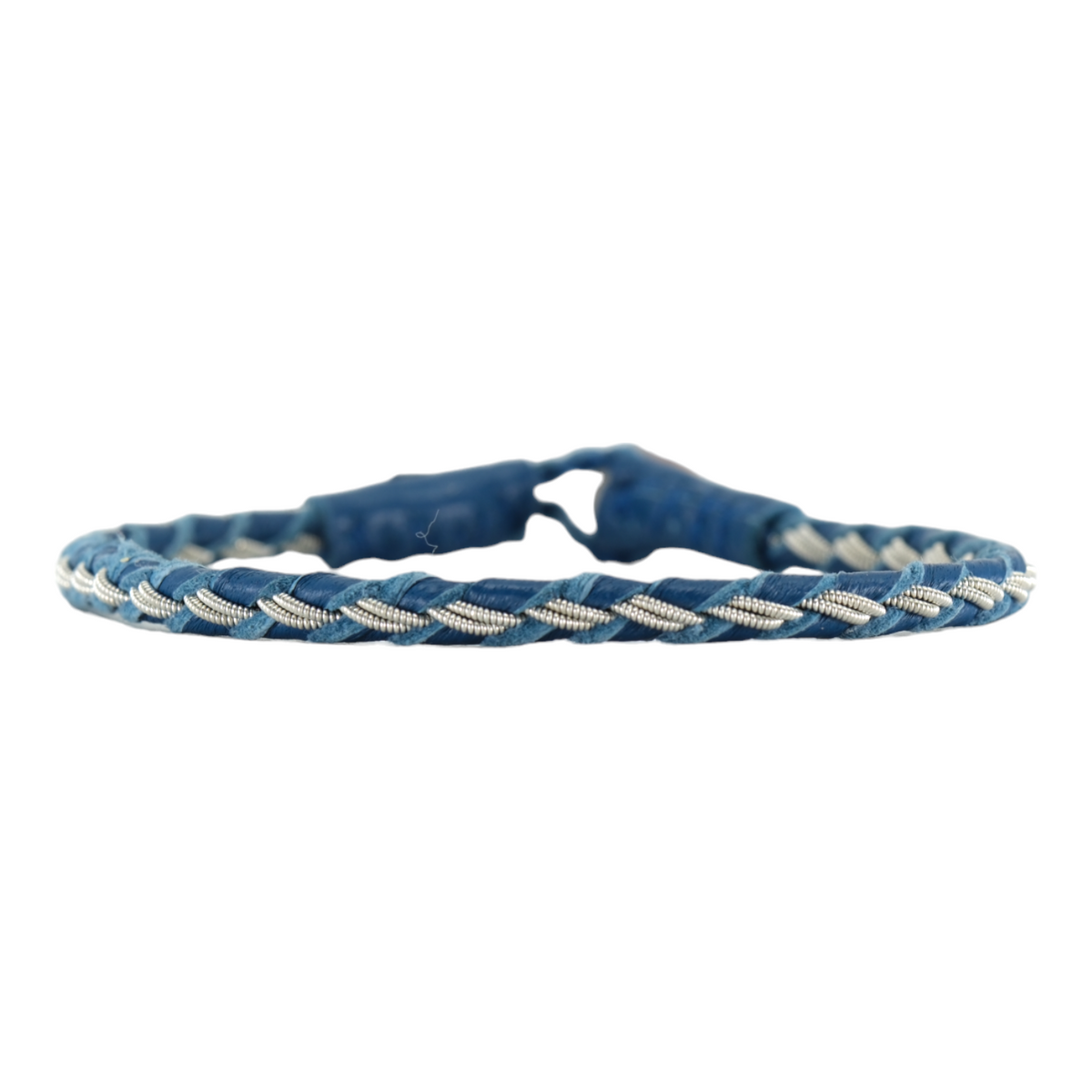 Handgjort tennarmband Stig från Arctic Collection i blått renskinn med flätad läderrem och silverfärgad tenntråd. Armbandet visas mot vit bakgrund med renhornsknapp.