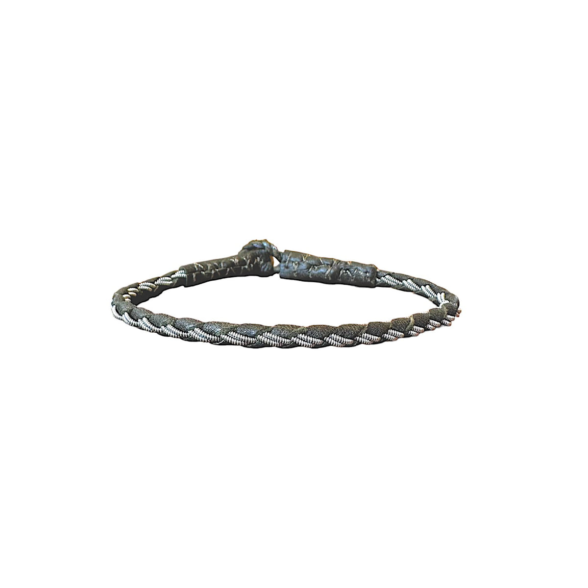 Handgjort tennarmband Stig från Arctic Collection i mörkgrönt renskinn med flätad läderrem och silverfärgad tenntråd. Armbandet visas mot vit bakgrund med renhornsknapp.