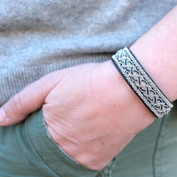 Handgjort läderarmband med fläta av silver och tenn på en kvinnas handled gjord av Arctic Collection
