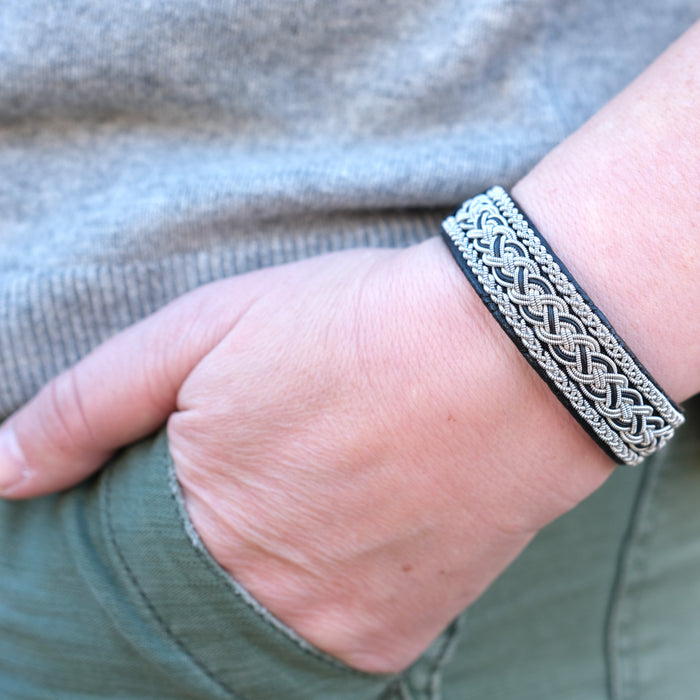 Handgjort läderarmband med fläta av silver och tenn på en kvinnas handled gjord av Arctic Collection
