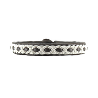 Handgjort tennarmband i renskinn med tenntrådsfläta och renhornsknapp, inspirerat av stormens kraft och nordisk vildmark.