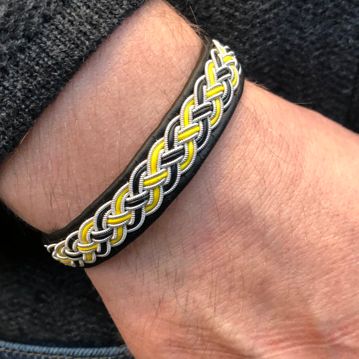 Supporerarmband I svart och gult, laganda AIK i renskinn. 